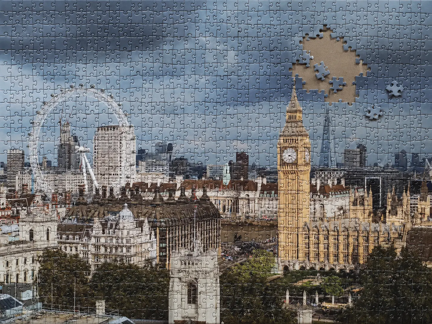 An unfinished thousand-piece jigsaw puzzle of the Palace of Westminster with a small missing section and loose pieces in the sky